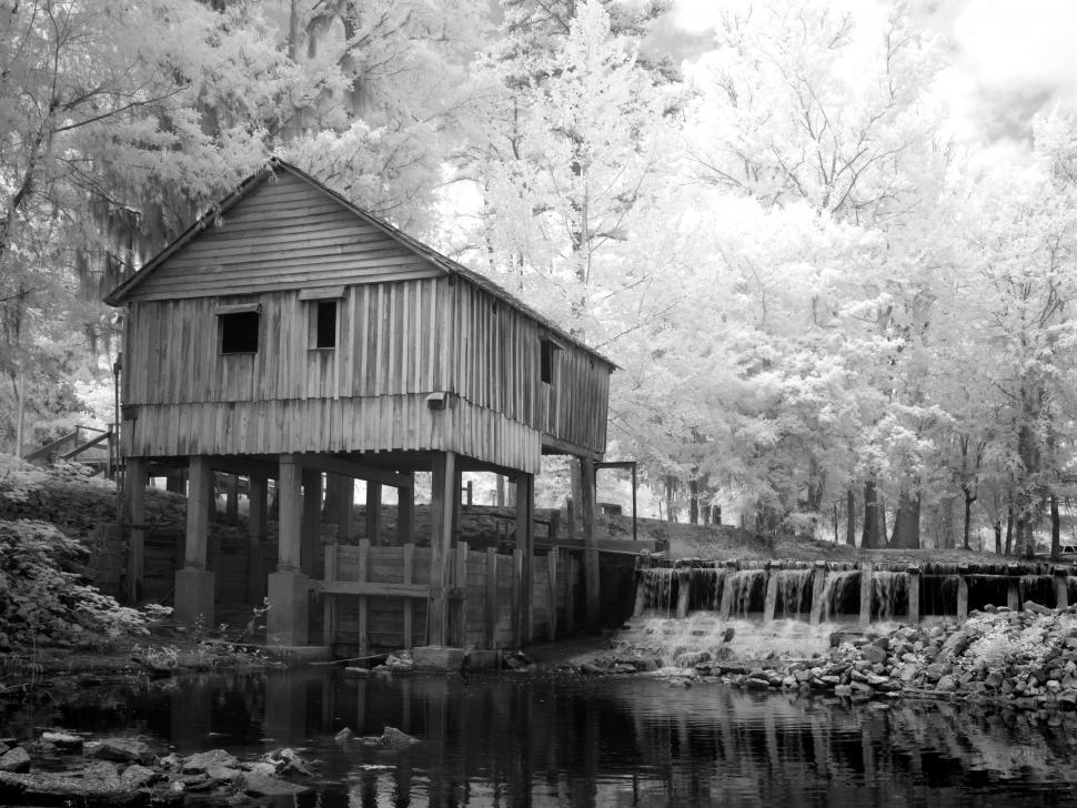 Free Image of Rikard\'s Mill Historical Park with wood house, river and trees  